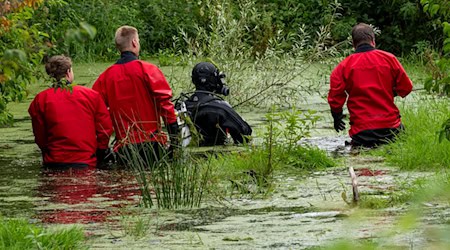 Taucher der Polizei suchten einen kleinen Weiher in der Gemeinde Taufkirchen nach der Vermissten ab. / Foto: Peter Kneffel/dpa