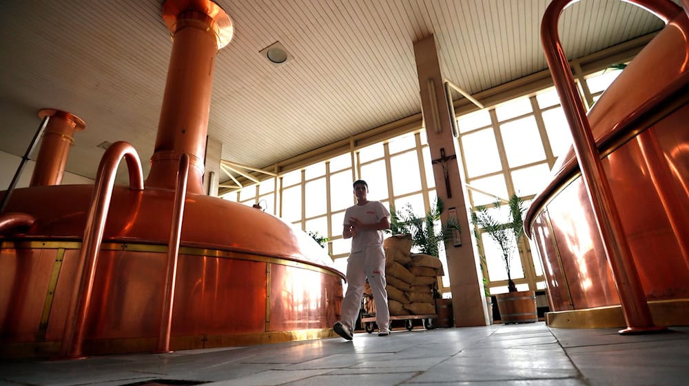Ein Arbeiter geht in der Brauerei Budweiser Budvar an Sudkesseln vorbei. / Foto: Petr David Josek/AP/dpa
