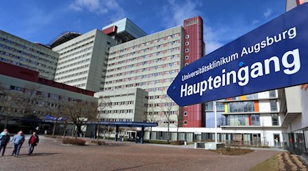 Ein Schild weist zum Haupteingang des Universitätsklinikums Augsburg. Das sanierungsbedürftige Klinikum soll jetzt auf einer angrenzenden Fläche neu gebaut werden. (Archivfoto) / Foto: Karl-Josef Hildenbrand/dpa