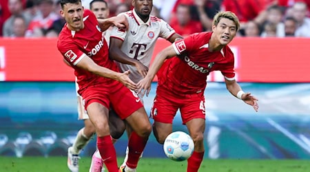 Bayerns Kingsley Coman (M) im Kampf mit zwei Freiburger Gegenspielern. / Foto: Sven Hoppe/dpa