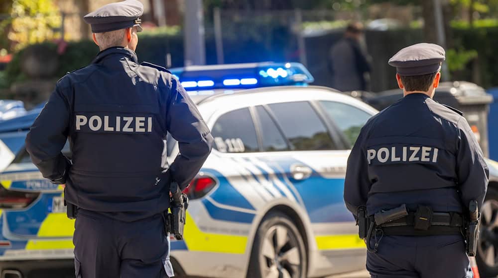 Polizisten stehen mit einem Streifenwagen am Haupteingang zum Oktoberfestgelände. (Archivbild) / Foto: Peter Kneffel/dpa