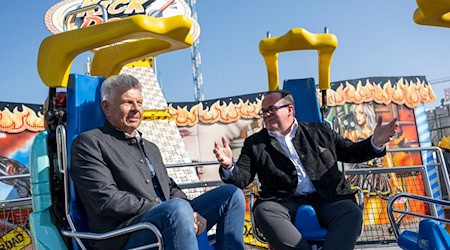 Der Oberbürgermeister und der Festleiter testen vor dem Wiesn-Start ein Fahrgeschäft. / Foto: Lennart Preiss/dpa