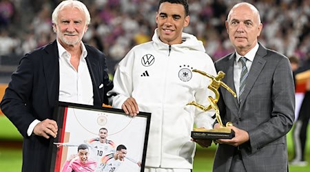 Rudi Völler (l) hört 2026 als DFB-Sportdirektor aus. Beim Ungarn-Spiel zeichnet er gemeinsam mit DFB-Präsident Bernd Neuendorf (r) Nationalspieler Jamal Musiala nach seinen drei EM-Toren aus.  / Foto: Federico Gambarini/dpa