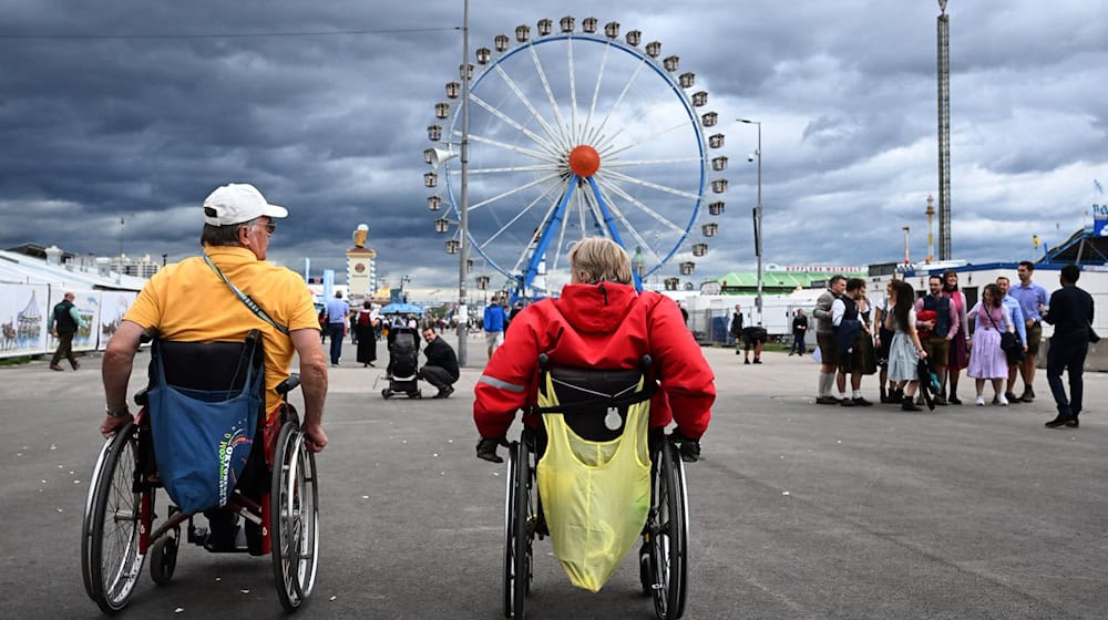 Werner Graßl (l) und Monika Burger auf dem Weg zum Riesenrad. / Foto: Felix Hörhager/dpa