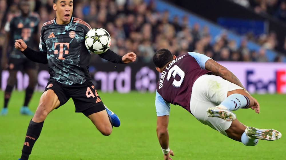 Jamal Musiala (l), hier im Einsatz gegen Aston Villa, muss vorerst pausieren. / Foto: Peter Kneffel/dpa