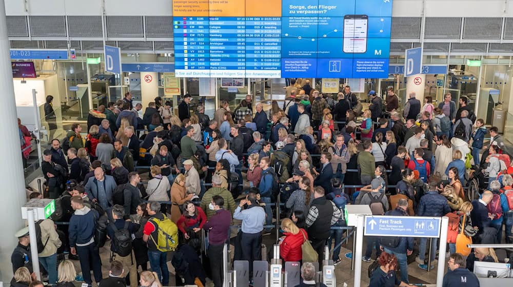 Solche Bilder mit endlosen Warteschlangen soll es möglichst nicht mehr vom Münchner Flughafen geben. Der Freistaat Bayern fordert schnelle Reformen für den zweitgrößten deutschen Airport. (Archivbild) / Foto: Peter Kneffel/dpa