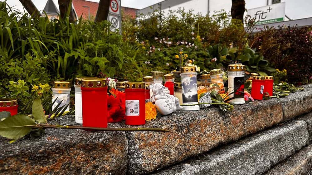 Nach dem Tod eines Obdachlosen nach einem mutmaßlichen Angriff stehen Blumen und Kerzen im Stadtzentrum von Immenstadt im Allgäu. Die Staatsanwaltschaft hat nun eine Mordanklage gegen einen jugendlichen Tatverdächtigen erhoben. (Archiv) / Foto: Lisa Hild/dpa