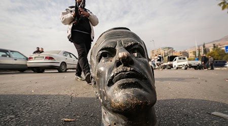 Ein abgetrennter Kopf einer Statue des verstorbenen syrischen Präsidenten Hafis al-Assad liegt in Damaskus auf der Straße. Islamistische Rebellen haben in Syrien die Macht übernommen. / Foto: Hussein Malla/AP/dpa