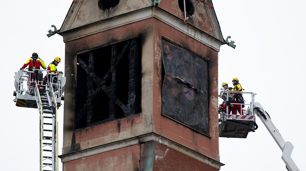 Feuerwehrleute sichern mit Spanngurten lose teile an dem beschädigten Turm des Seniorenheimes.  / Foto: Sven Hoppe/dpa