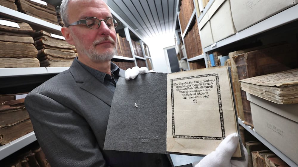 Christoph Engelhard, Stadtarchivar von Memmingen, zeigt im Archiv eine Druckausgabe der «Zwölf Artikel» aus dem Jahr 1525. / Foto: Karl-Josef Hildenbrand/dpa