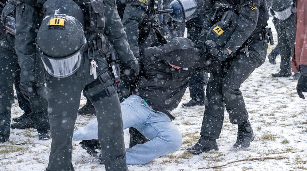 Polizisten ergreifen einen Teilnehmer einer Demonstration auf dem Königsplatz. / Foto: Pia Bayer/dpa