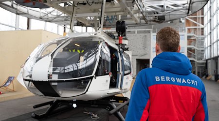 Im Bergwacht-Zentrum für Sicherheit und Ausbildung steht ein Mitglied der Bergwacht Bayern vor einem Hubschrauber-Modell. (Archivbild) / Foto: Magdalena Henkel/dpa