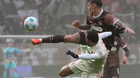  St. Paulis Eric Smith (r) und Augsburgs Alexis Claude-Maurice kämpfen um den Ball. / Foto: Marcus Brandt/dpa