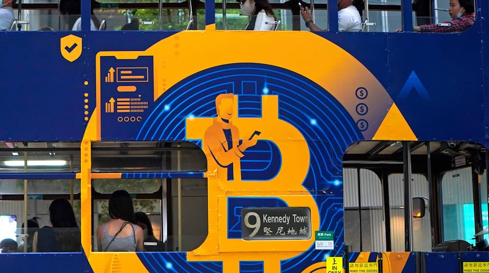 Eine Werbung für die Kryptowährung Bitcoin auf einer Hongkonger Straßenbahn. Kryptoanleger weltweit glauben laut einer Umfrage, dass es weiter aufwärts geht. (Foto: Illustration) / Foto: Kin Cheung/AP/dpa