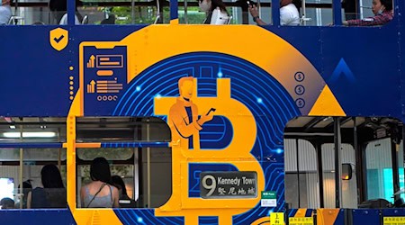 Eine Werbung für die Kryptowährung Bitcoin auf einer Hongkonger Straßenbahn. Kryptoanleger weltweit glauben laut einer Umfrage, dass es weiter aufwärts geht. (Foto: Illustration) / Foto: Kin Cheung/AP/dpa