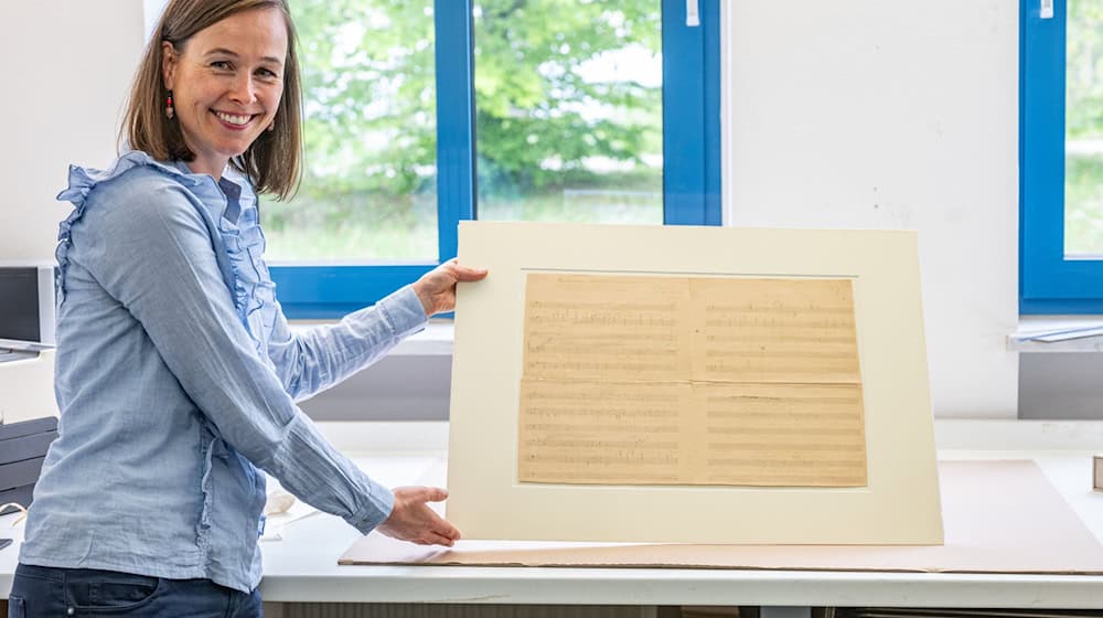 Komponisten-Enkelin Anne Wöhner brachte das vergilbte Notenblatt in die Werkstatt des Restaurators Werner Obermeier in Niederbayern. (Archivbild) / Foto: Armin Weigel/dpa