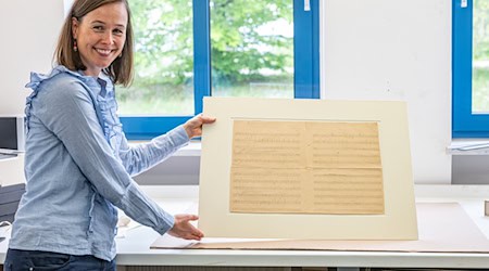 Komponisten-Enkelin Anne Wöhner brachte das vergilbte Notenblatt in die Werkstatt des Restaurators Werner Obermeier in Niederbayern. (Archivbild) / Foto: Armin Weigel/dpa