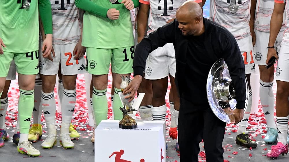 Bayern-Trainer Vincent Kompany stellt bei der Meisterparty eine Kakadu-Figur auf den Sockel. / Foto: Sven Hoppe/dpa