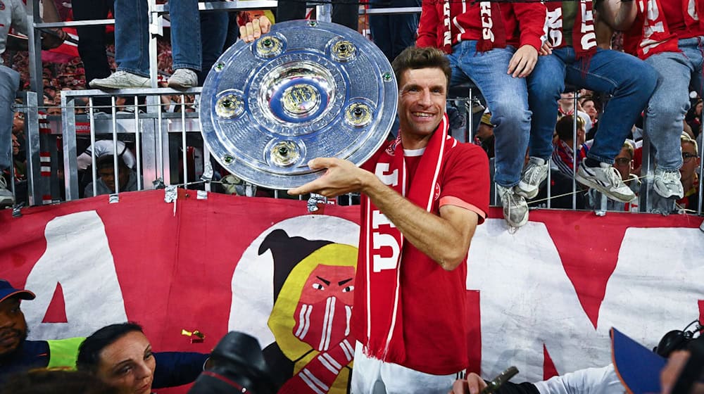 Thomas Müller zeigt die Meisterschale. / Foto: Tom Weller/dpa