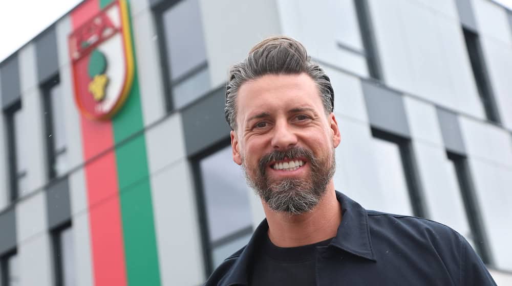 Der neue Trainer Sandro Wagner posiert vor der Geschäftsstelle des FC Augsburg. / Foto: Karl-Josef Hildenbrand/dpa