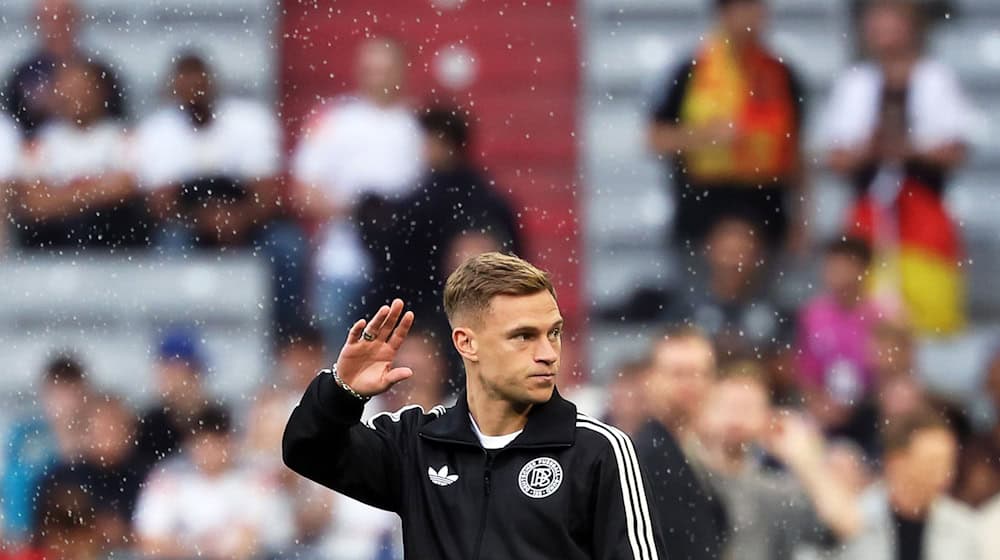 Kapitän Joshua Kimmich winkt nach der Ankunft im Münchner Stadion den Fans zu. / Foto: Christian Charisius/dpa