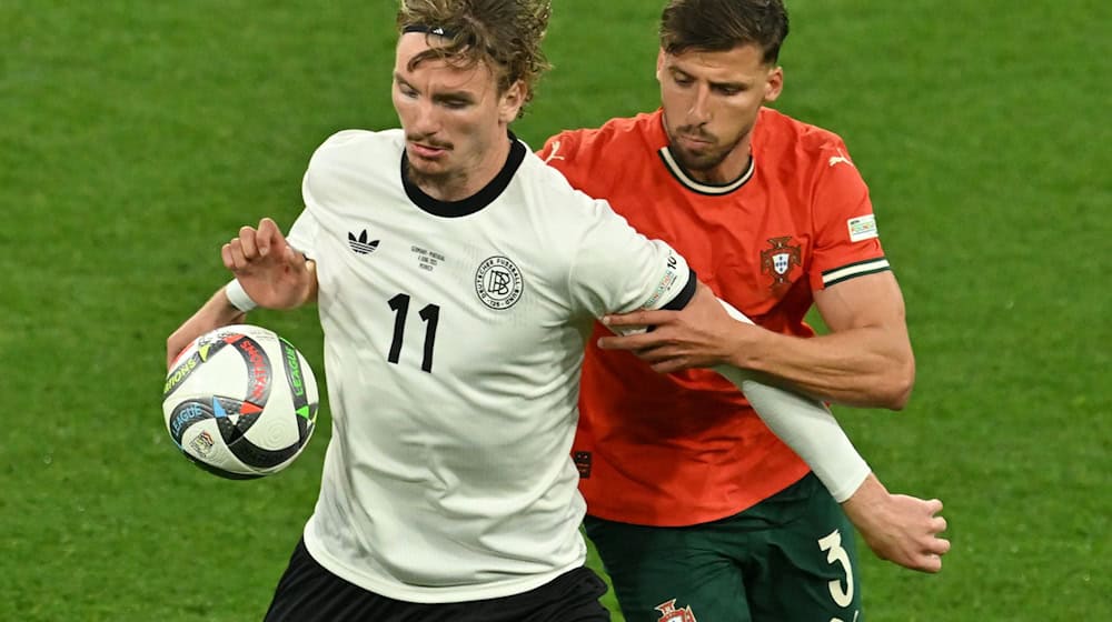 Nick Woltemade (l) hatte bei seinem Länderspiel-Debüt gegen Portugals Abwehrrecken einen schweren Stand. / Foto: Peter Kneffel/dpa