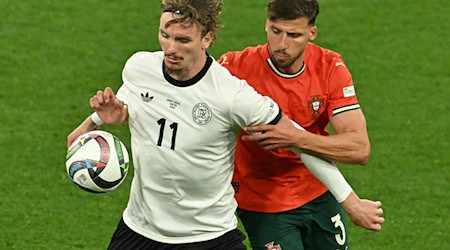 Nick Woltemade (l) hatte bei seinem Länderspiel-Debüt gegen Portugals Abwehrrecken einen schweren Stand. / Foto: Peter Kneffel/dpa