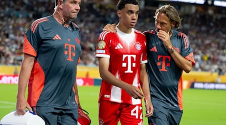 Jamal Musiala musste nur 25 Minuten nach seiner Einwechselung angeschlagen vom Platz, begleitet von Teamarzt (r) und Physiotherapeut.  / Foto: Sven Hoppe/dpa
