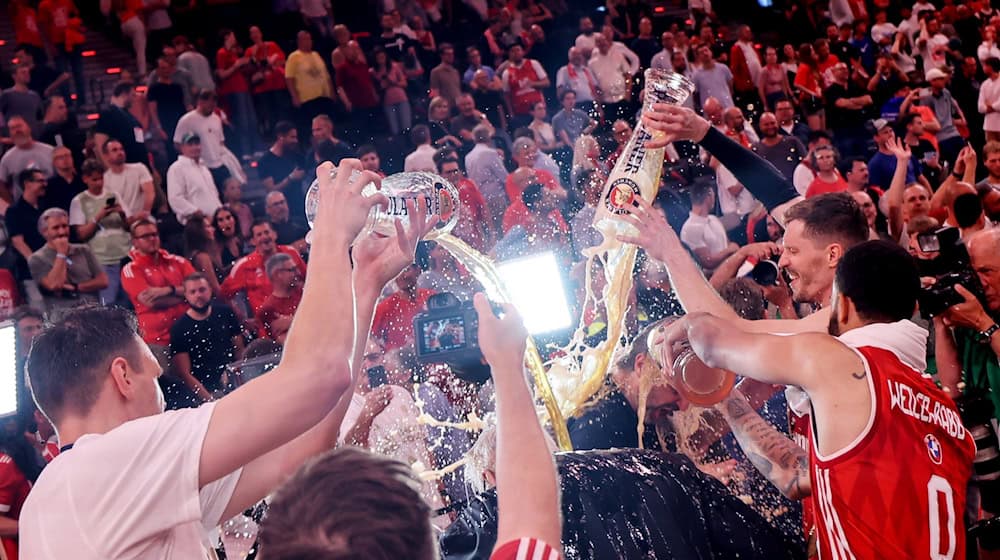 Die Bayern-Basketballer überschütten Coach Herbert mit Bier. / Foto: Matthias Stickel/dpa