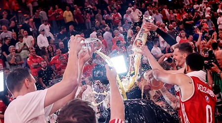 Die Bayern-Basketballer überschütten Coach Herbert mit Bier. / Foto: Matthias Stickel/dpa