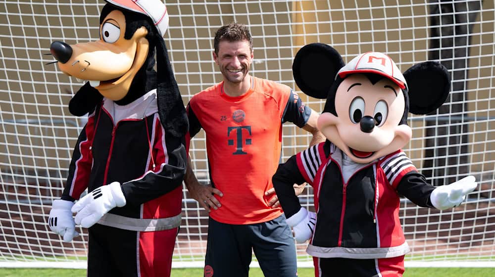 Thomas Müller mit Goofy und Micky Maus. / Foto: Sven Hoppe/dpa