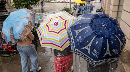 Bei Regenwetter und Schauern bleibt der Regenschirm ein wichtiges Accessoire.  / Foto: Peter Kneffel/dpa