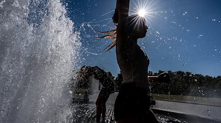 Temperaturen von annähernd 40 Grad in der Hauptstadt - diese Touristen nutzen einen Brunnen zur Abkühlung. / Foto: Michael Kappeler/dpa