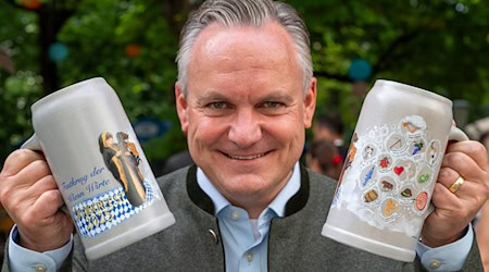 Wiesnchef Christian Scharpf zeigt den aktuellen Maßkrug der Wiesnwirte. / Foto: Peter Kneffel/dpa