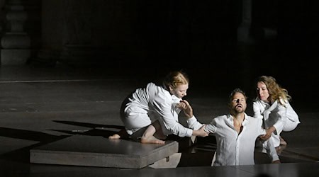 Der Jedermann (Philipp Hochmair) im Juli 2025 in seinem Grab - gehalten vom Glauben (Regine Zimmermann) und seinen Werken (Kathleen Morgeneyer). (Archivbild) / Foto: Barbara Gindl/APA/dpa