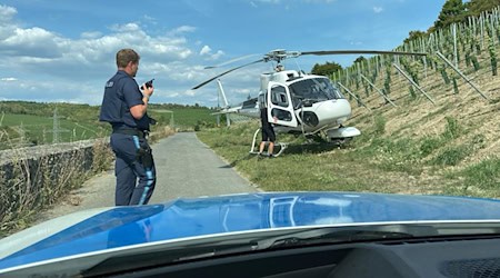 Ein ziviler Hubschrauber musste nach einem Maschinenschaden in den Würzburger Weinbergen landen. / Foto: Polizei Würzburg-Stadt/dpa