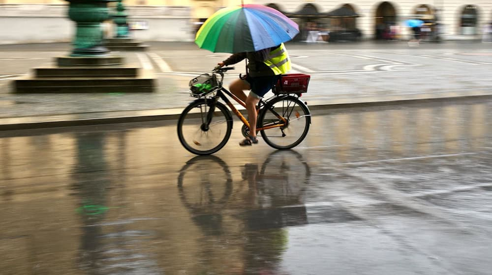 Wer nicht nass werden will, sollte etwas gegen den Regen dabeihaben.  / Foto: Peter Kneffel/dpa
