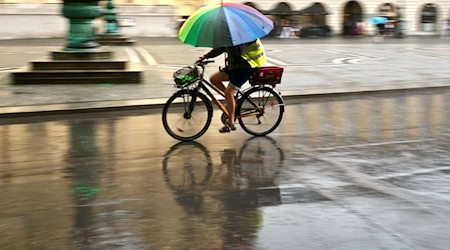 Wer nicht nass werden will, sollte etwas gegen den Regen dabeihaben.  / Foto: Peter Kneffel/dpa
