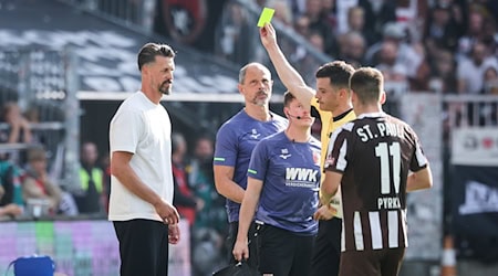 Schiedsrichter Harm Osmers zeigt Trainer Sandro Wagner (FC Augsburg, l) die gelbe Karte. / Foto: Christian Charisius/dpa