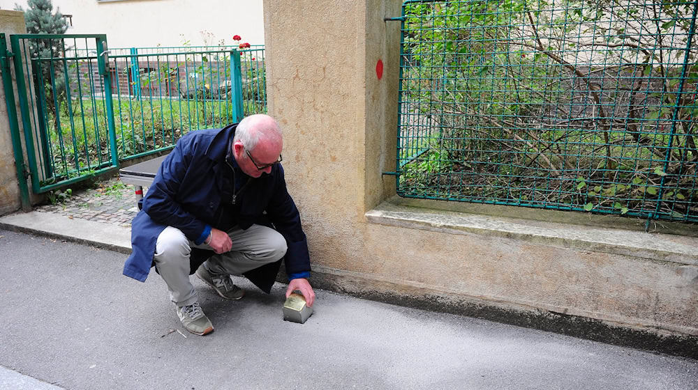 Gregory Tigrid hält den Stolperstein für seinen Vater Pavel Tigrid. In Prag erinnert vor dem Haus Kouřimská 5 ein neuer Stolperstein an den tschechischen Schriftsteller und Ex-Kulturminister Pavel Tigrid (1917-2003).  / Foto: Michael Heitmann/dpa post-slider