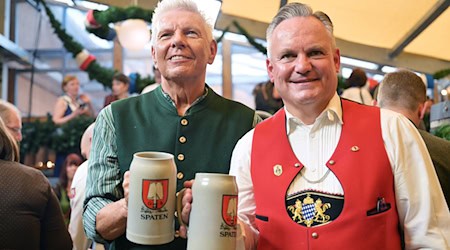 Münchens OB Dieter Reiter (l.) und Wiesnchef Christian Scharpf stoßen am ersten Oktoberfesttag miteinander an.  / Foto: Peter Kneffel/dpa