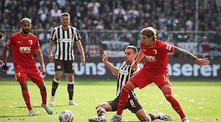 Im Zweikampf: Kristijan Jakić vom FC Augsburg (r) und St. Paulis James Sands. / Foto: Christian Charisius/dpa