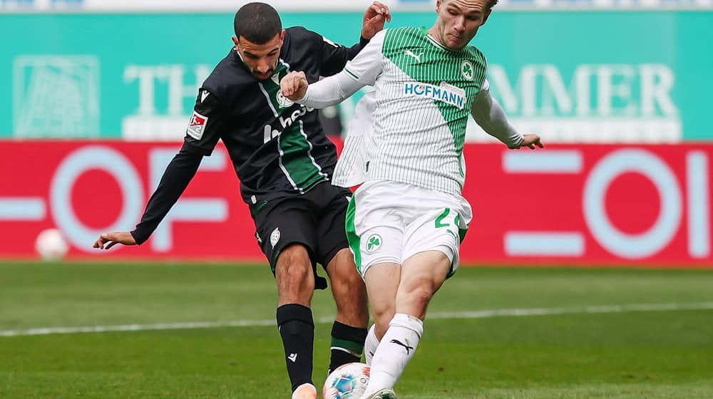 Greuther Fürths Marco John blockt den Schuss des Hannoveraners Waniss Taibi. (Archivbild) / Foto: Daniel Löb/dpa