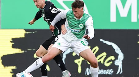 Hannover-Profi Maurice Neubauer (links) und der Fürther Lukas Reich kämpfen um den Ball. / Foto: Daniel Löb/dpa