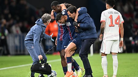 Auf Betreuer gestützt wird der am Fuß verletzte PSG-Spieler Achraf Hakimi (M) vom Platz geführt.  / Foto: Federico Gambarini/dpa