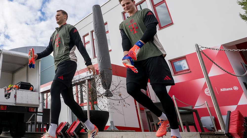 Torwart Manuel Neuer (l) und Ersatzkeeper Jonas Urbig auf dem Weg auf den Trainingsplatz. / Foto: Peter Kneffel/dpa