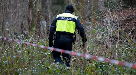 Ein Polizist nimmt an der Durchsuchung von einem Waldstück im Forstenrieder Park teil.  / Foto: Sven Hoppe/dpa