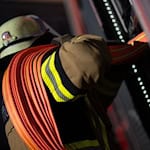 Feuerwehrleute löschen den Brand auf dem landwirtschaftlichen Anwesen (Symbolbild) / Foto: Marijan Murat/dpa