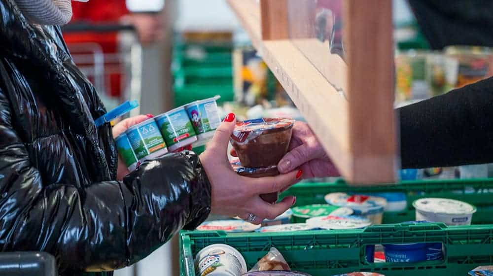 Eine Kundin (l) der Tafel Coburg bekommt Joghurt und Pudding. Der Landesverband Tafel Bayern e. V. besteht aus insgesamt 171 Mitgliedstafeln. (Archivbild) / Foto: Daniel Vogl/dpa