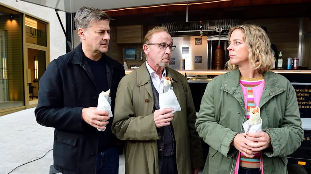 Harald Neuhauser (l, Marcus Mittermeier), Ludwig Schaller (Alexander Held) und Angelika Flierl (Bernadette Heerwagen) stehen vor einem Imbissstand. / Foto: Jürgen Olczyk,/ZDF/dpa